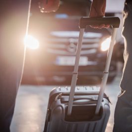 a person holding a luggage leving their transfer