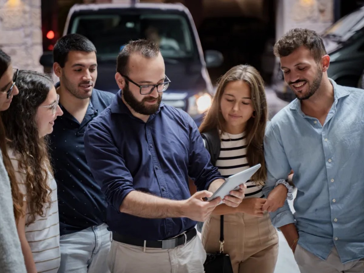 a group of people looking at a cell phone